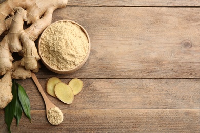 Photo of Fresh ginger root, powder and leaves on wooden table, flat lay. Space for text