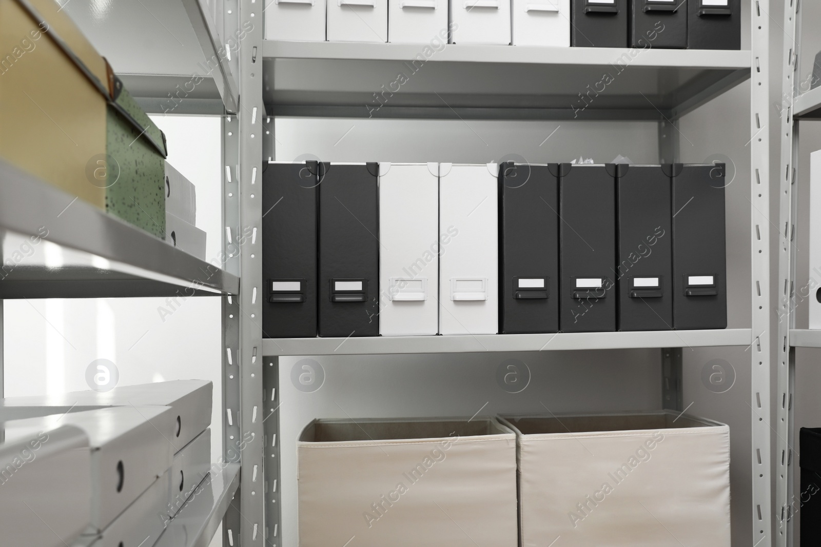 Photo of Folders and boxes with documents on shelves in archive