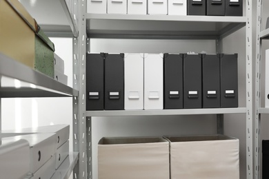 Folders and boxes with documents on shelves in archive