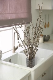 Photo of Beautiful blooming pussy willow branches in kitchen