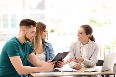 Photo of Young couple meeting with consultant in office