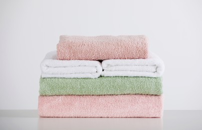 Photo of Soft color folded towels on white table