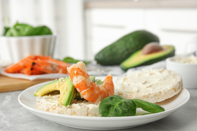 Photo of Puffed rice cake with shrimp and avocado on grey marble table indoors