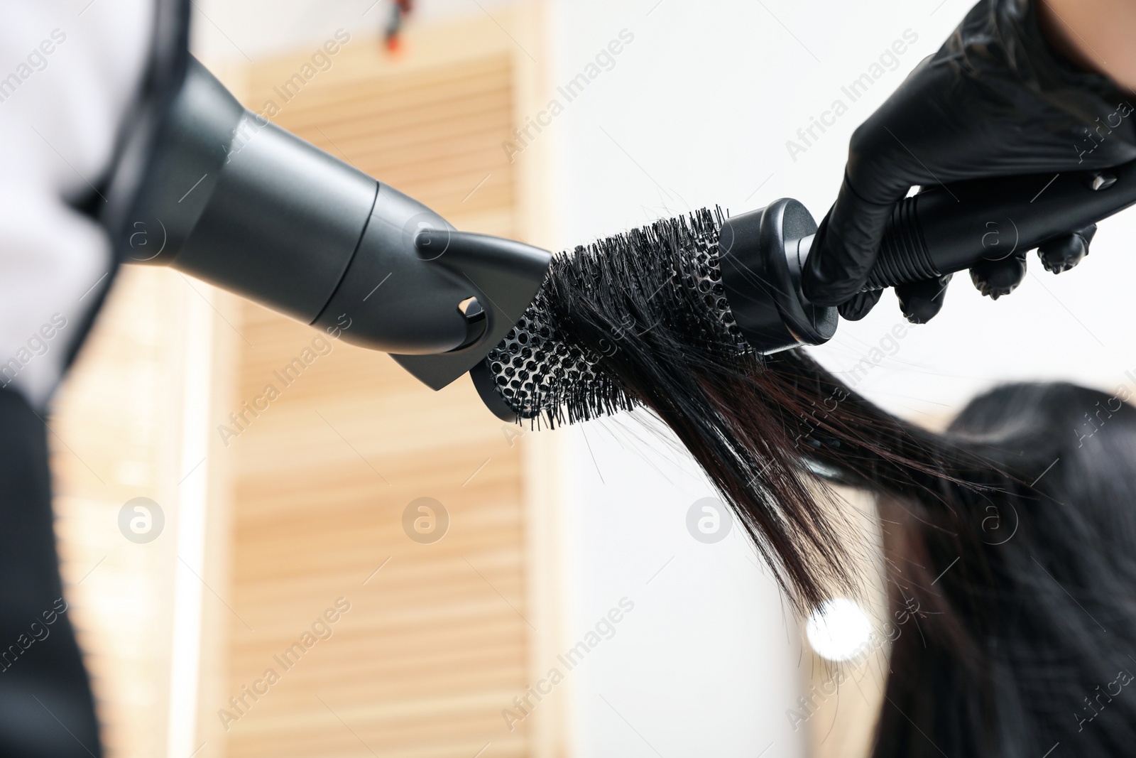 Photo of Professional stylist working with client in beauty salon, closeup. Hairdressing services during Coronavirus quarantine