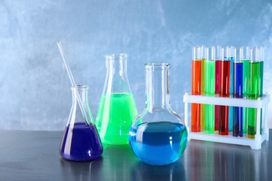 Photo of Different glassware with samples on table in chemistry laboratory