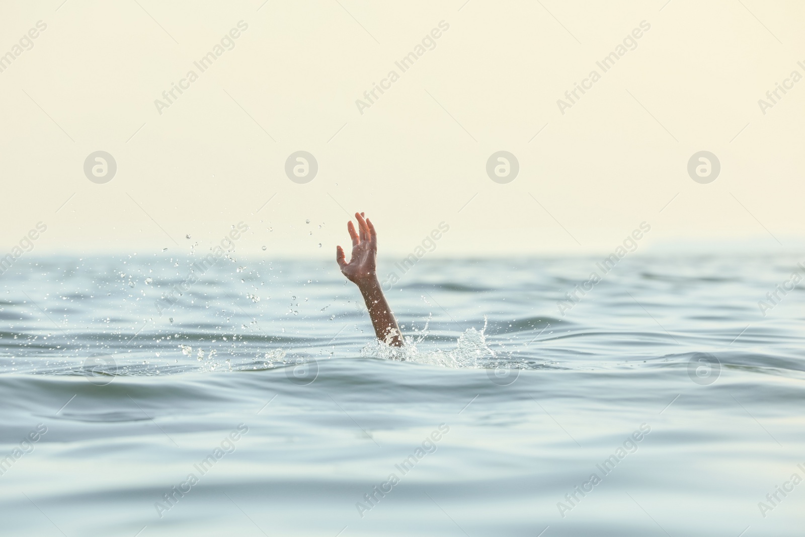 Photo of Drowning woman reaching for help in sea