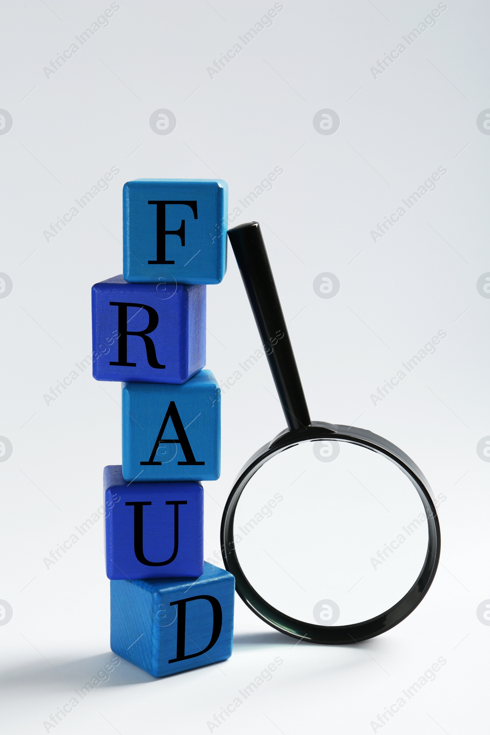 Photo of Blank cubes and magnifying glass on light background