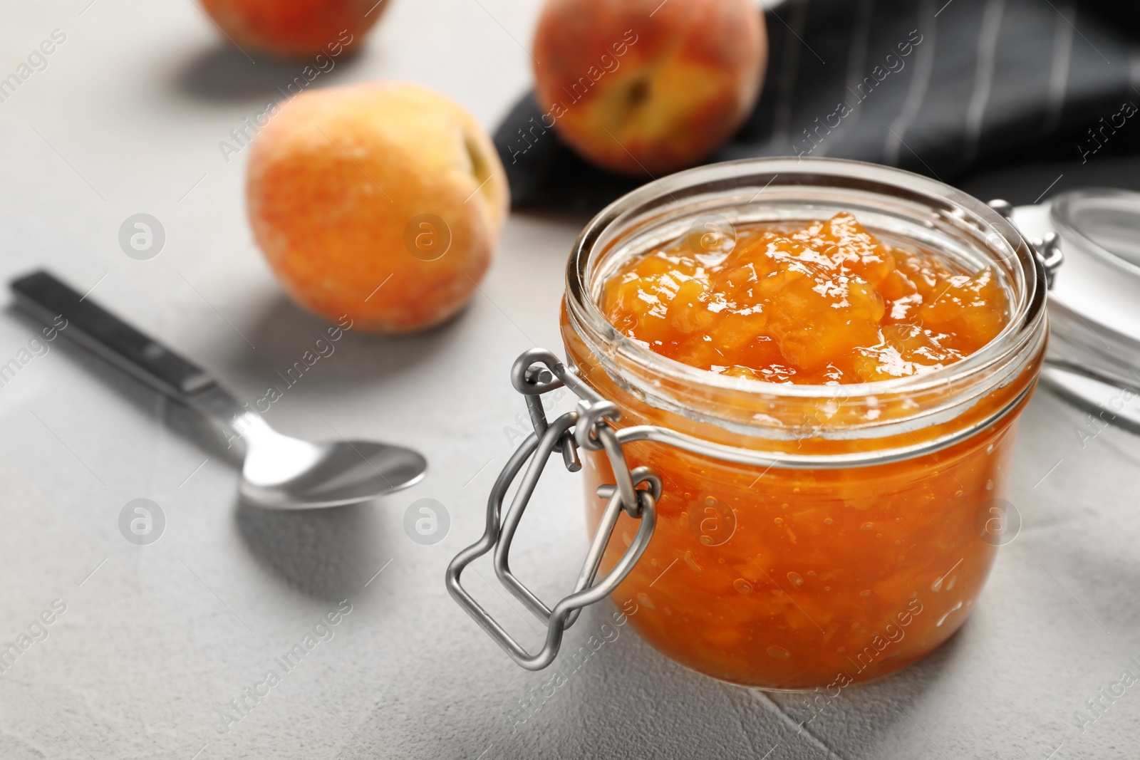 Photo of Jar with tasty peach jam on table