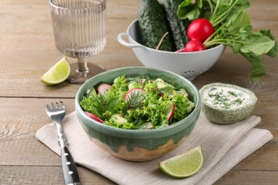 Delicious salad with radish, lettuce and dill served on wooden table