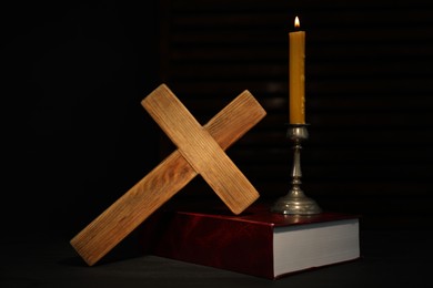 Photo of Church candle, Bible and wooden cross on table