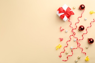 Photo of Flat lay composition with serpentine streamers and Christmas decor on beige background. Space for text