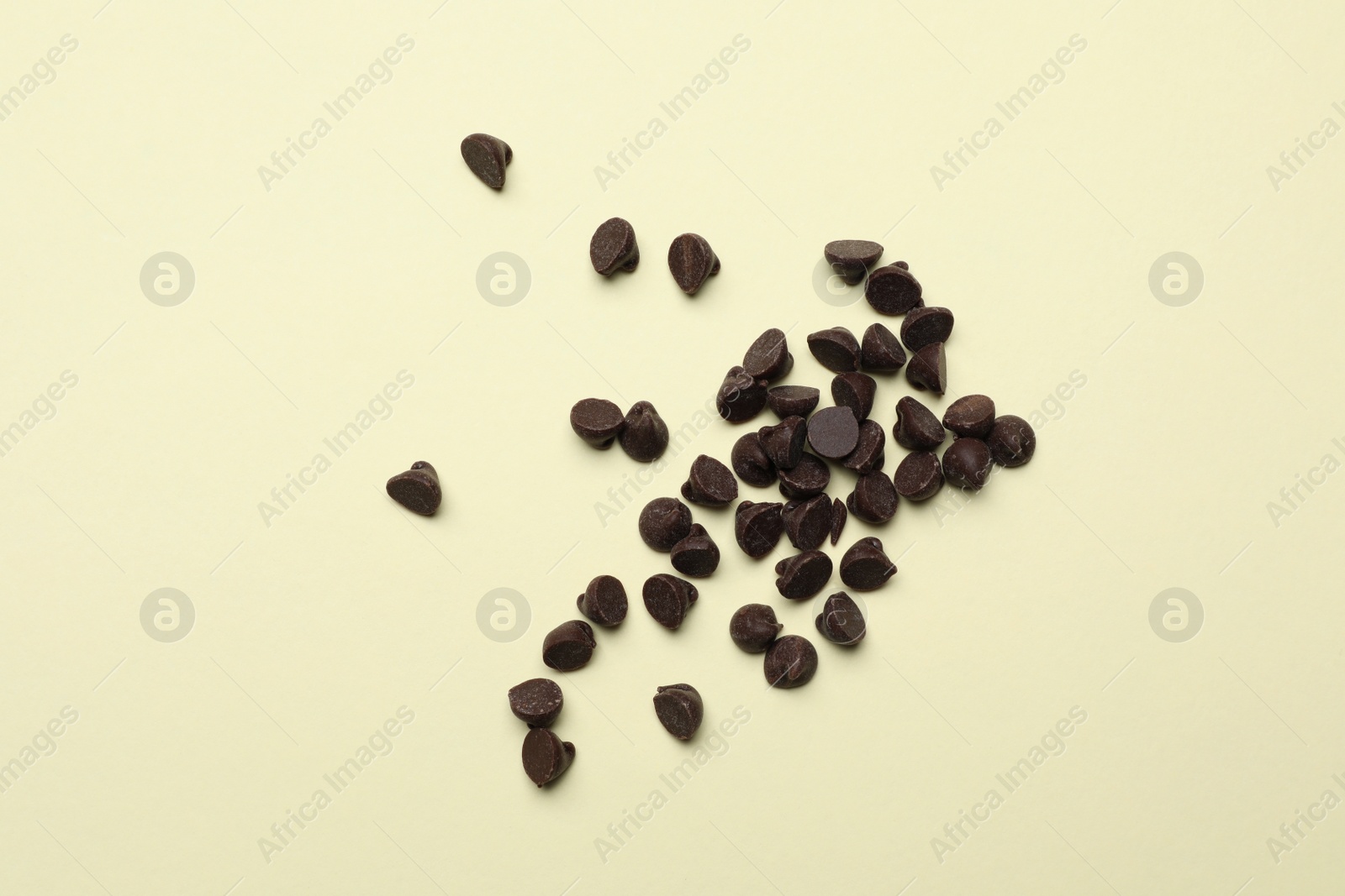 Photo of Pile of delicious chocolate chips on beige background, top view