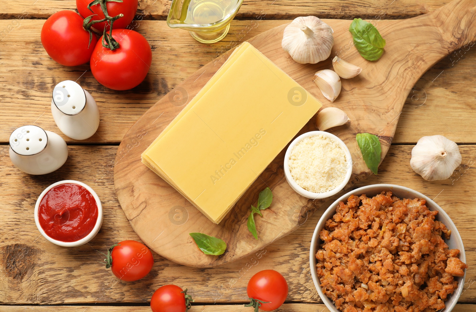 Photo of Flat lay composition with products for cooking lasagna on wooden table