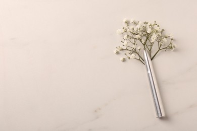 Bullet and beautiful gypsophila flowers on light marble table, flat lay. Space for text