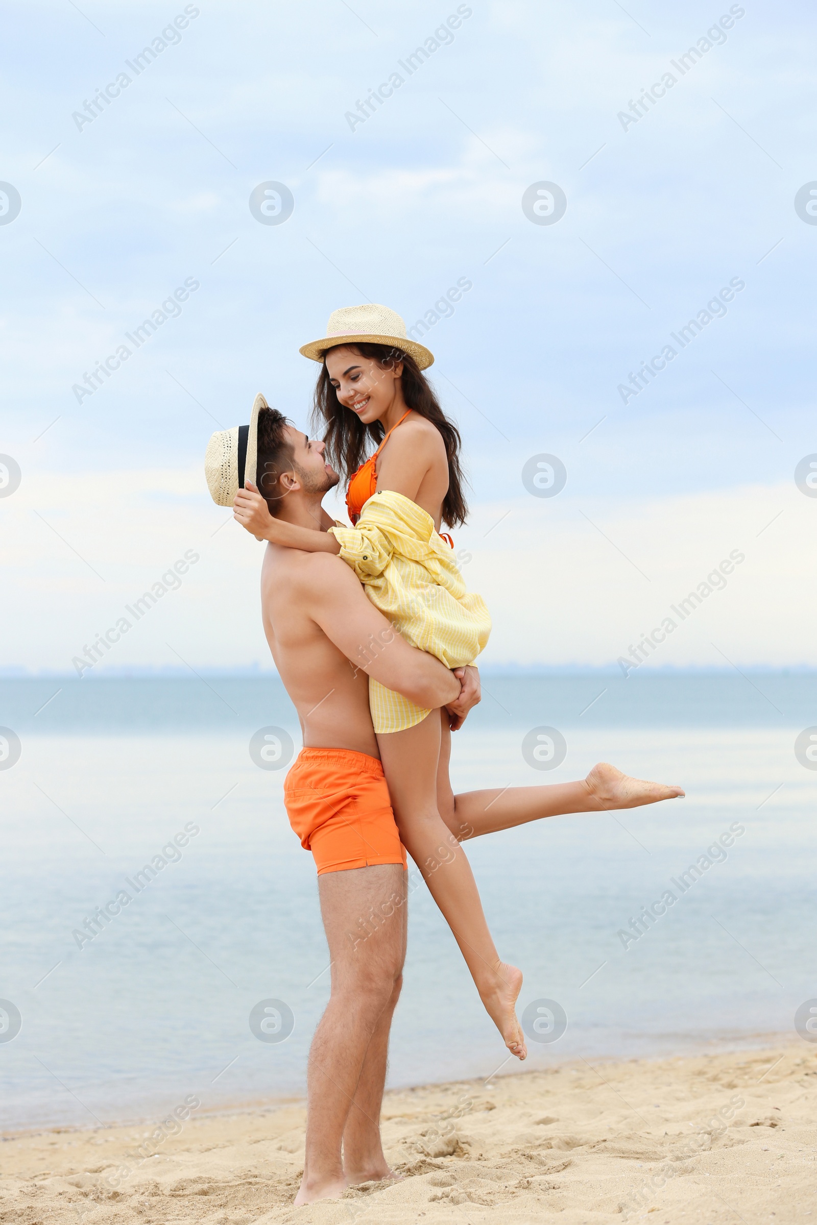 Photo of Happy young couple spending time together on beach near sea