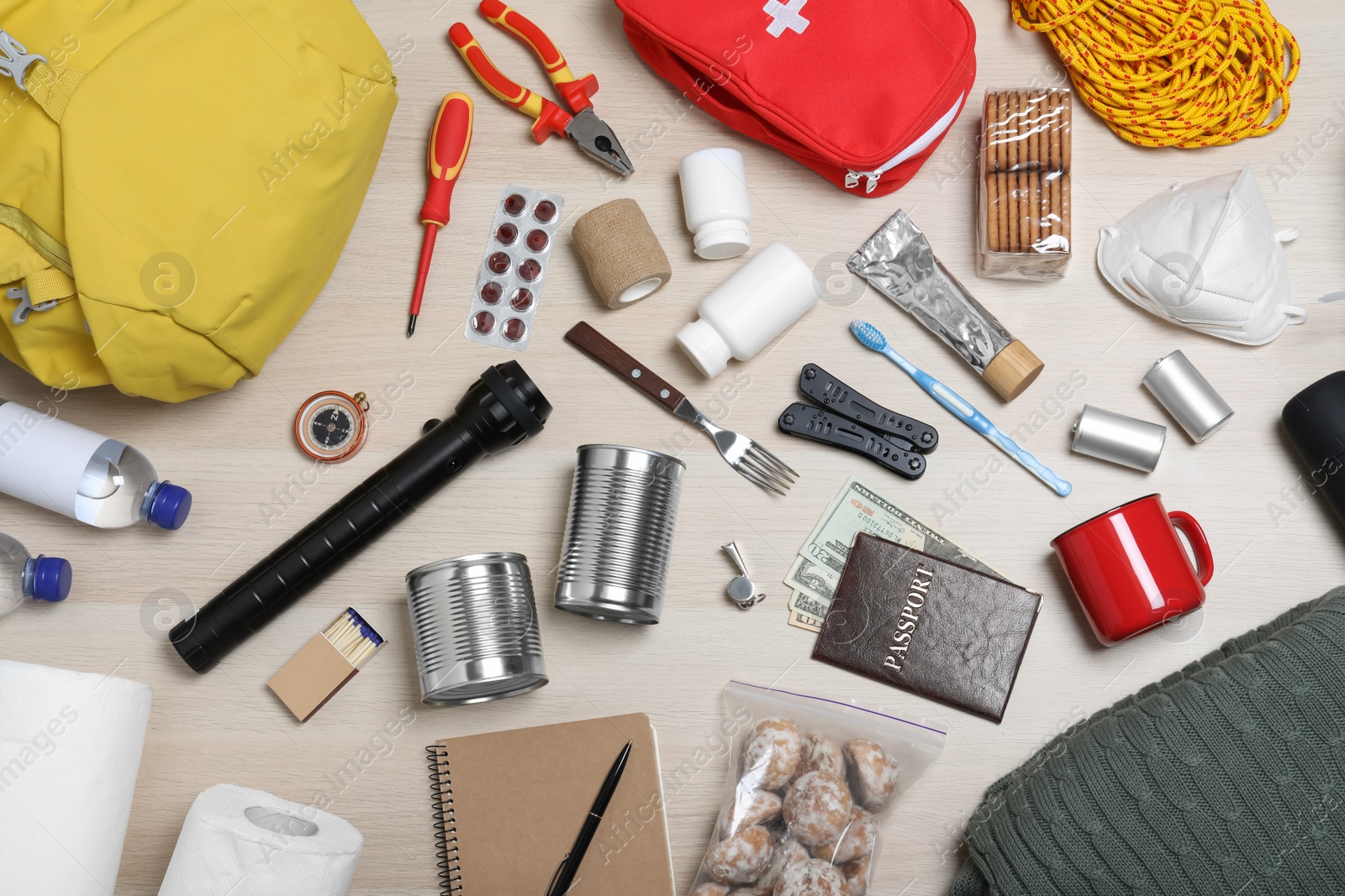 Photo of Disaster supply kit for earthquake on wooden table, flat lay