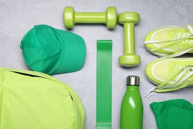 Different sports equipment on light grey table, flat lay