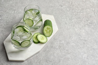 Photo of Composition with glasses of fresh cucumber water and space for text on grey background
