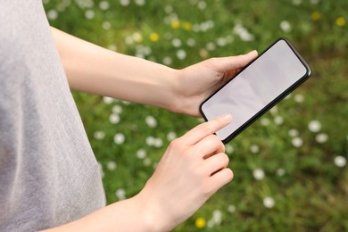 Photo of Woman using mobile phone outdoors, closeup view