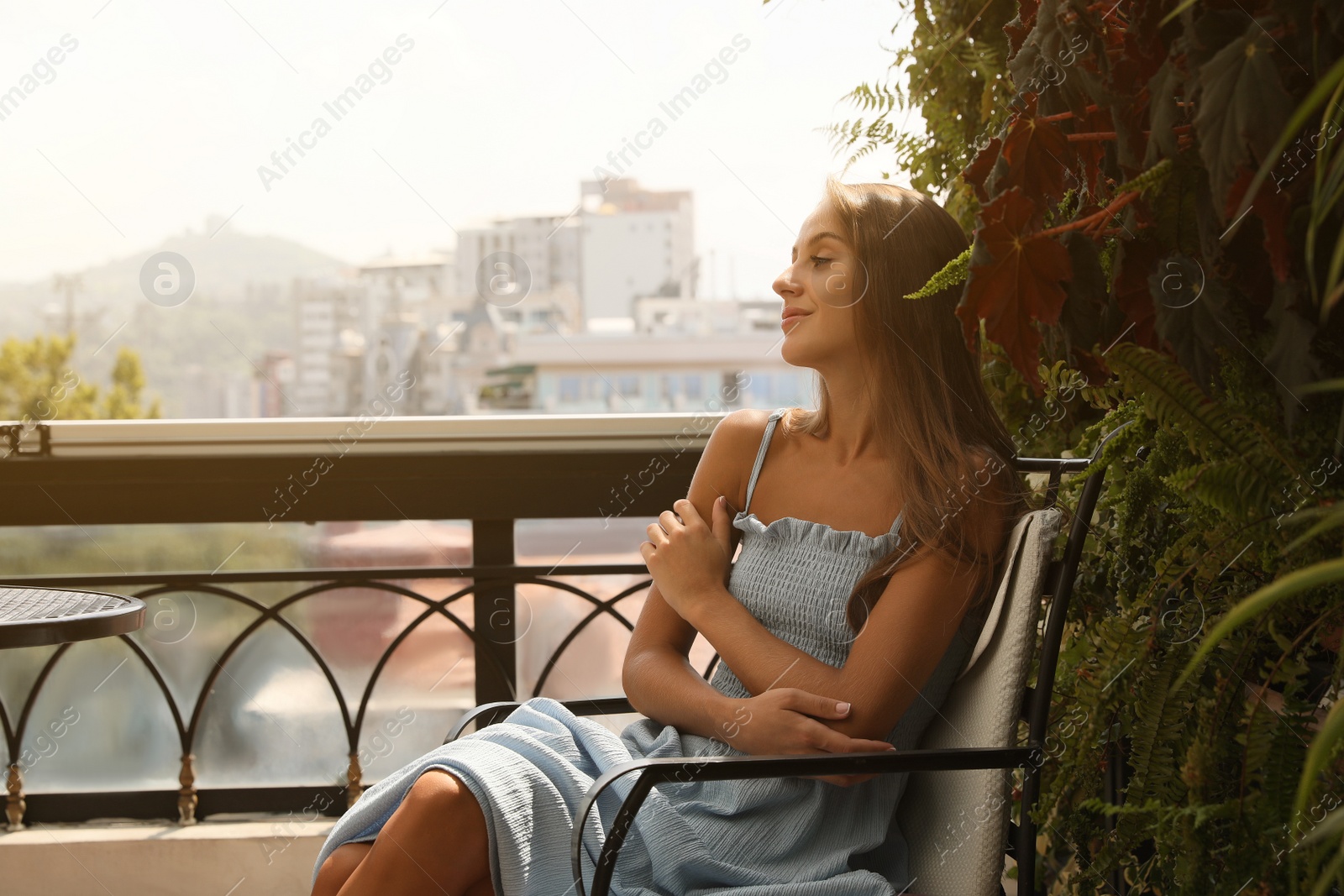 Photo of Beautiful young woman on balcony. Space for text