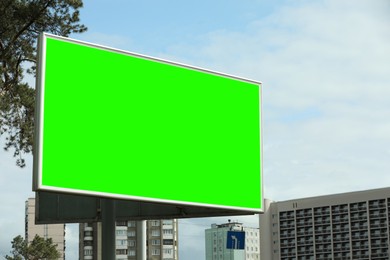 Image of Chroma key compositing. Big empty billboard with green screen in city. Mockup for design
