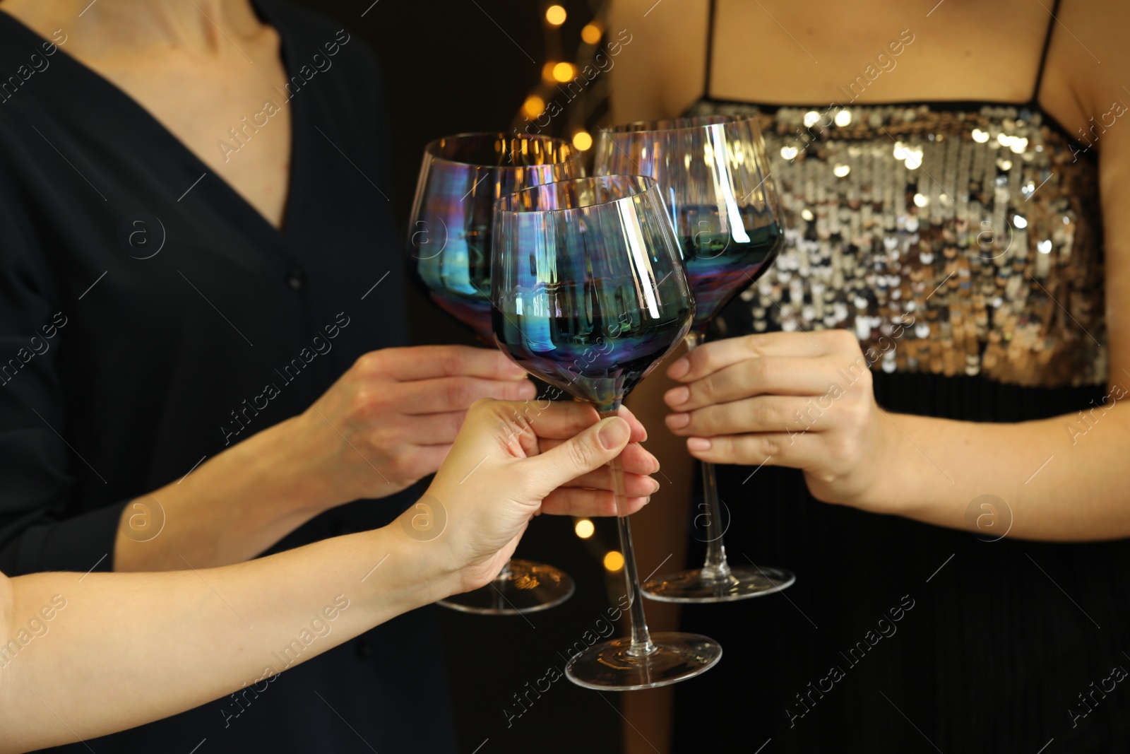 Photo of Women clinking glasses of red wine at party, closeup