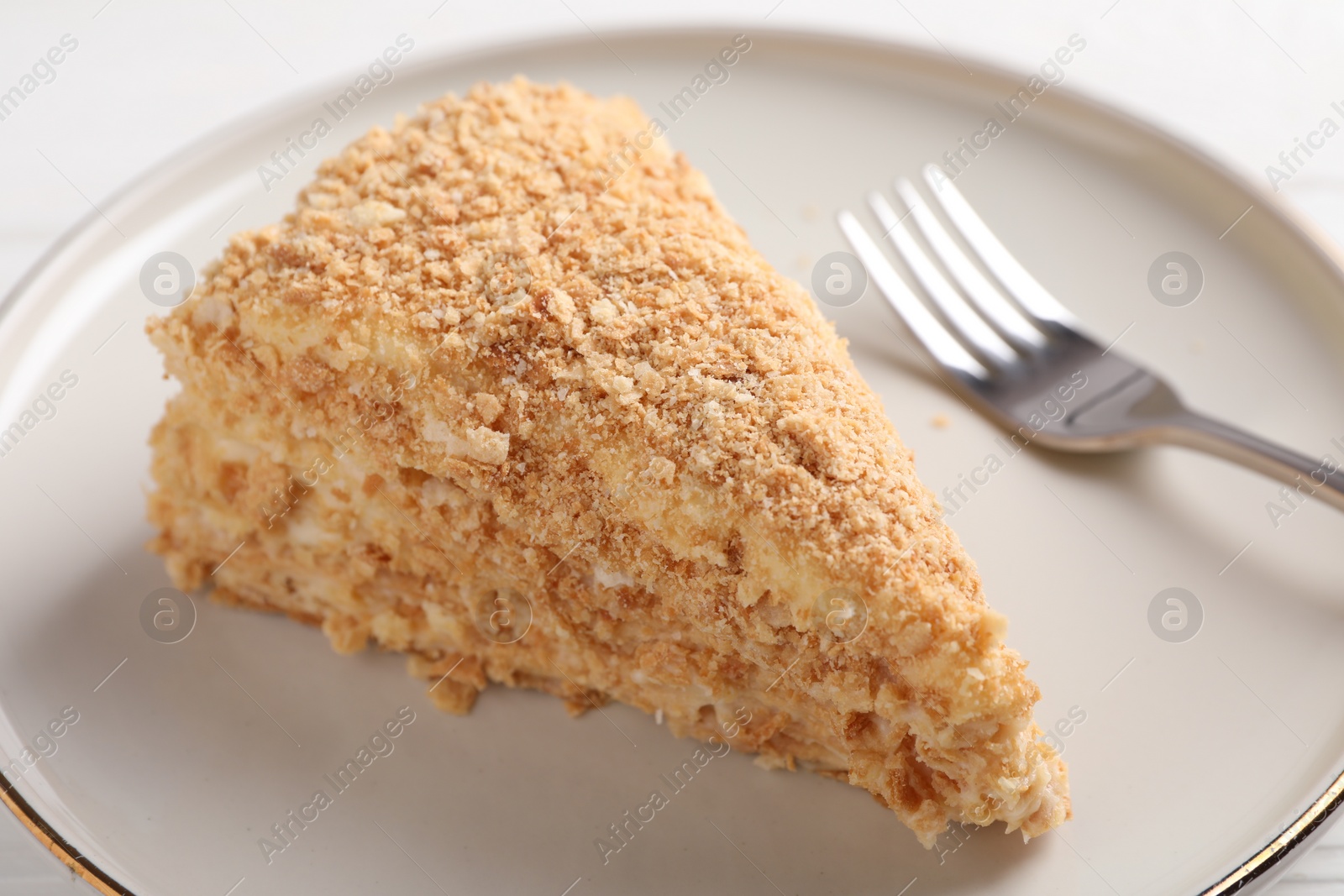 Photo of Piece of delicious Napoleon cake served on table, closeup