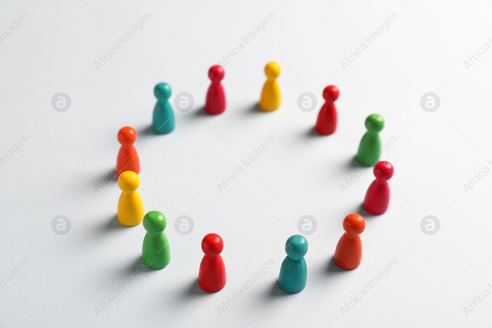 Photo of Colorful pawns on white background. Social inclusion concept