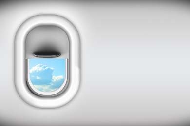 Image of View on blue sky with clouds through open airplane porthole, space for text
