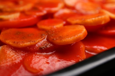 Tasty baked parsnips with red sauce, closeup