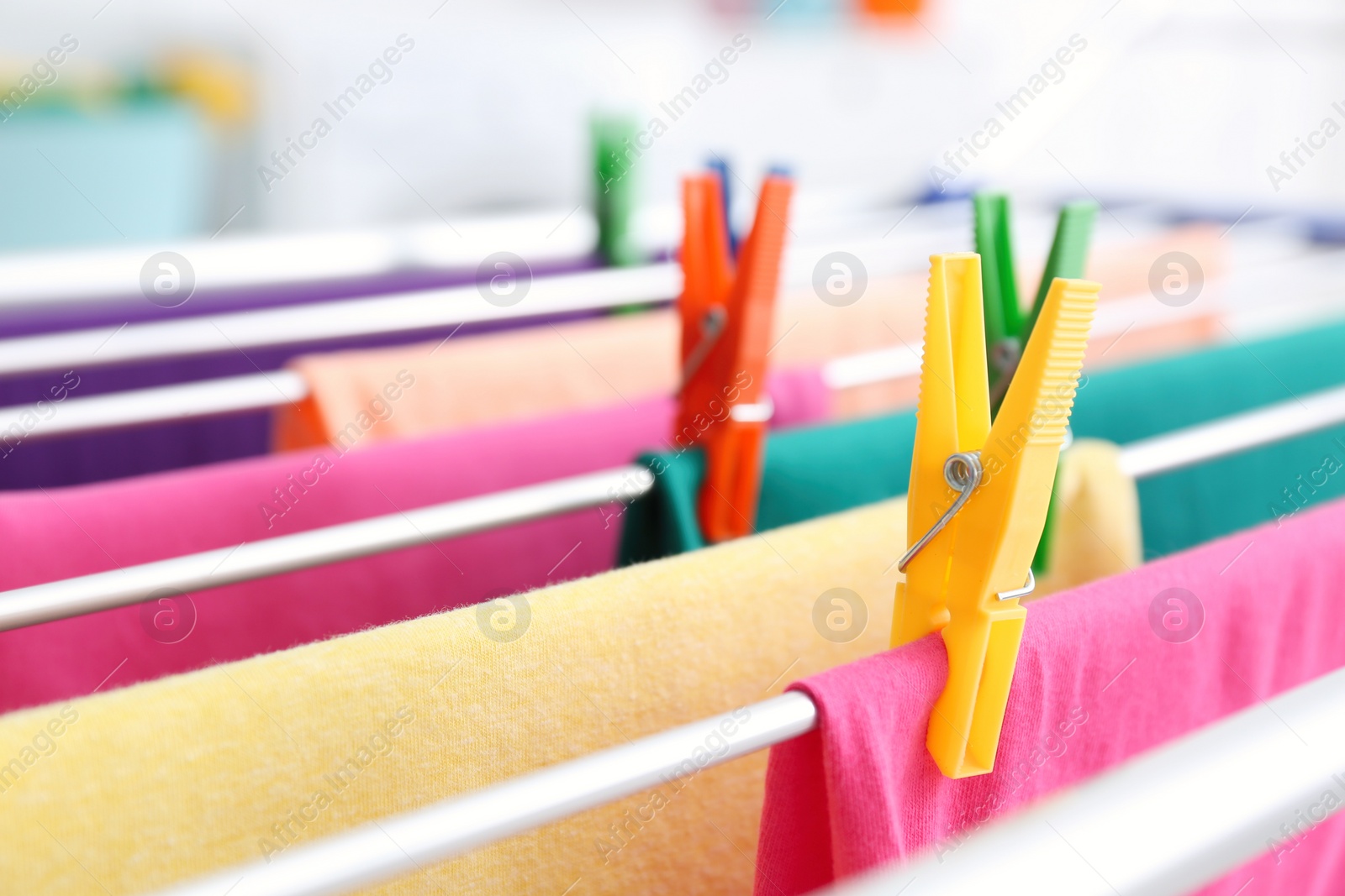 Photo of Clean laundry hanging on drying rack indoors, closeup