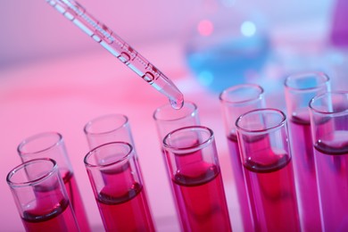 Photo of Dripping reagent into test tube with red liquid, closeup. Laboratory analysis