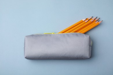 Many sharp pencils in pencil case on light grey background, top view