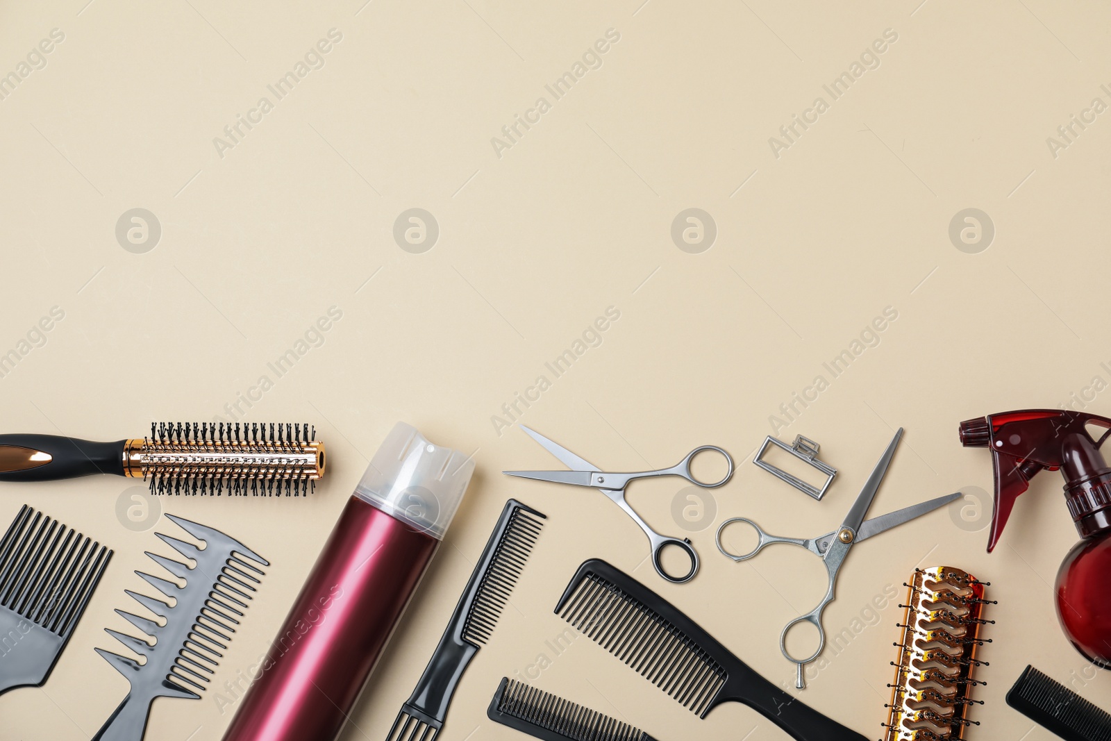 Photo of Flat lay composition of professional scissors and other hairdresser's equipment on beige background, space for text. Haircut tool