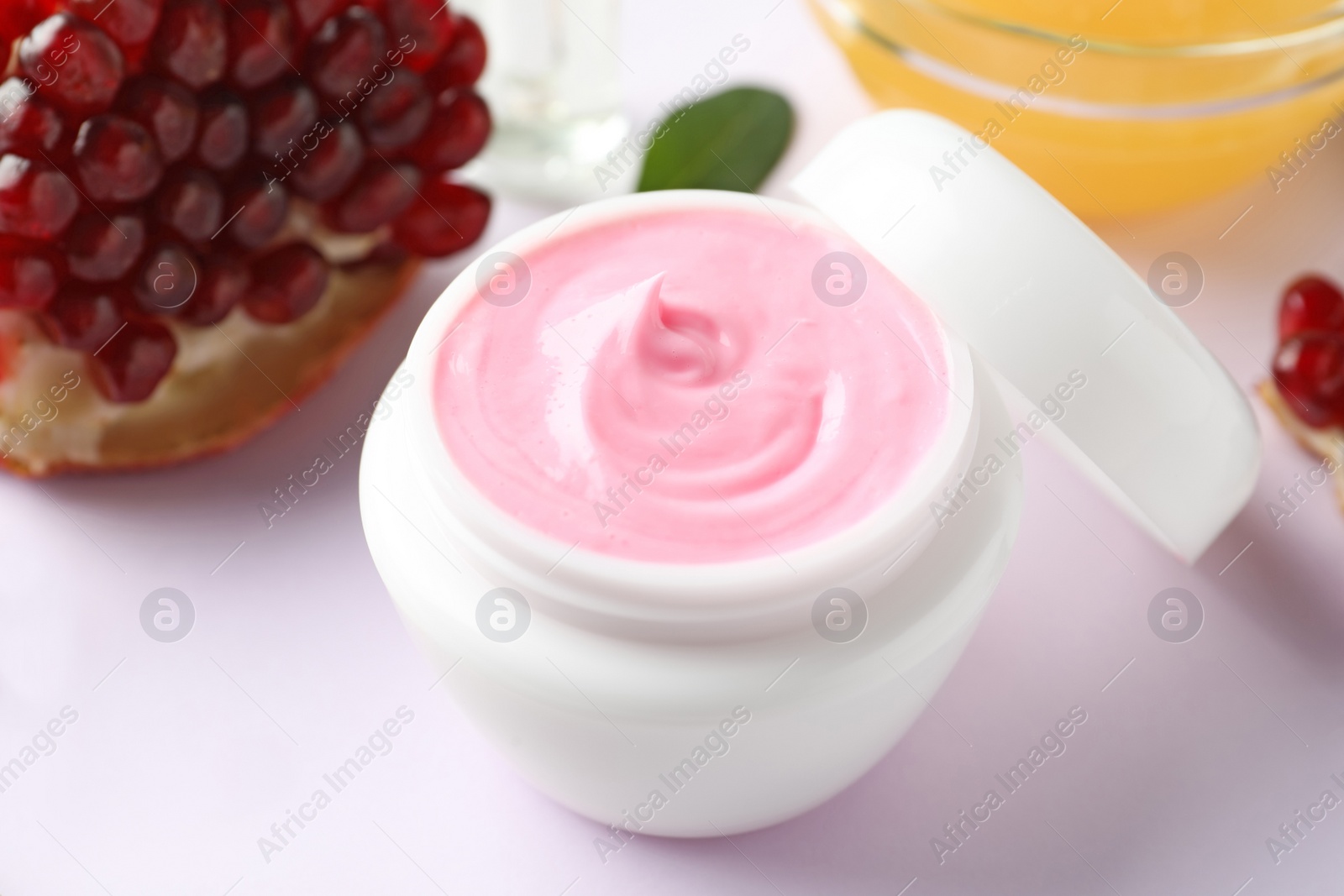 Photo of Jar of facial mask, pomegranate and fresh honey on white background. Natural organic cosmetics