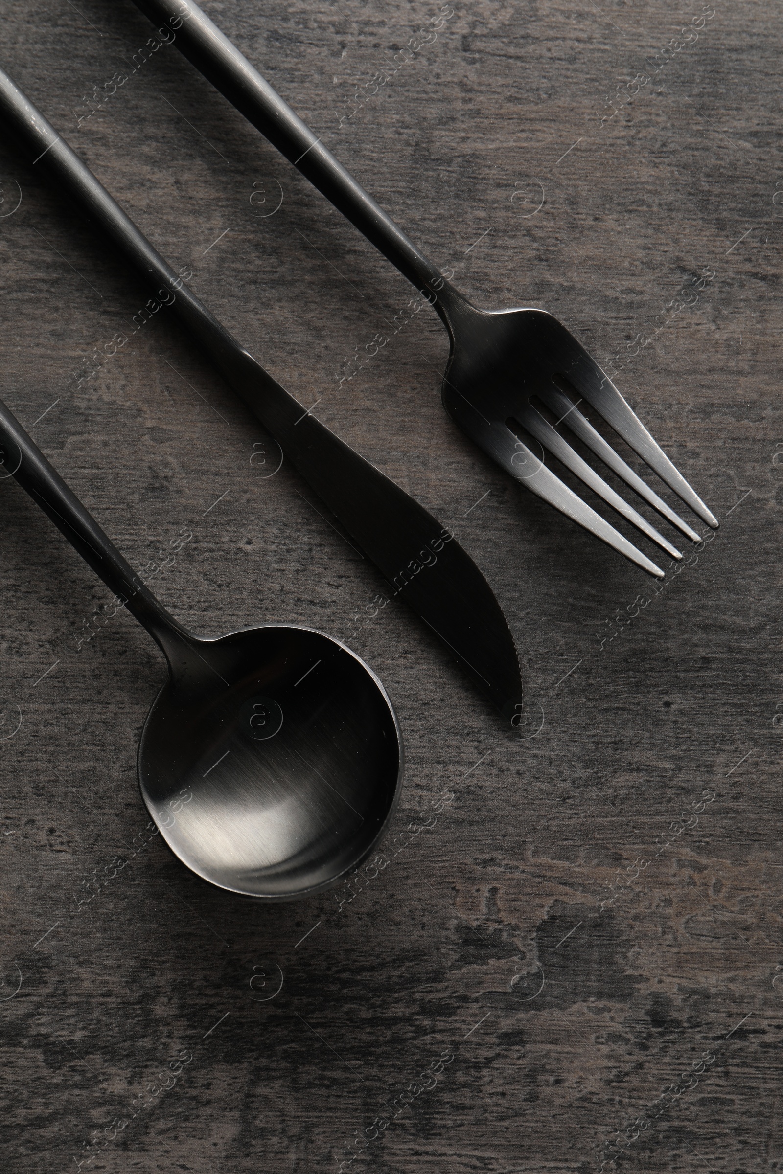 Photo of Stylish cutlery on grey table, flat lay