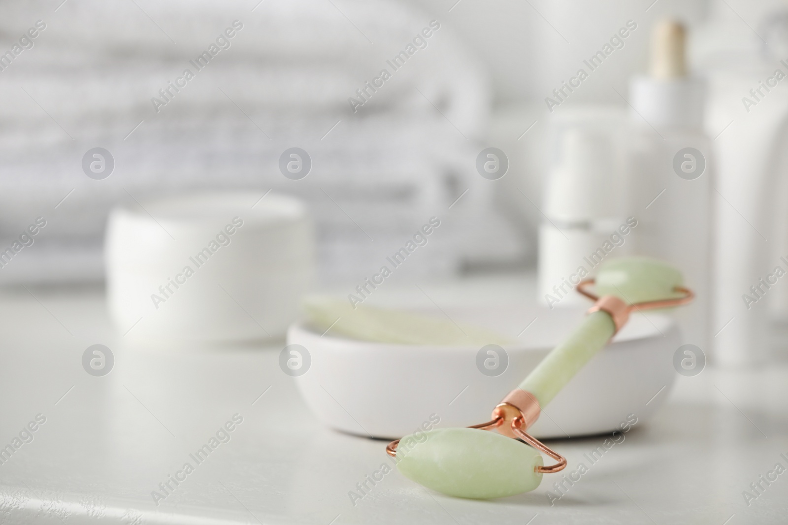 Photo of Natural face roller on white table, closeup. Space for text