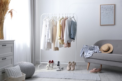 Photo of Dressing room interior with clothing rack and sofa