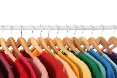 Photo of Many t-shirts hanging in order of rainbow colors, closeup