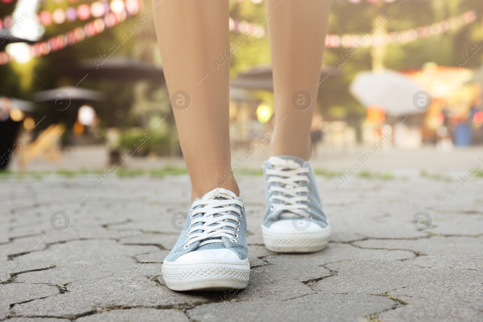 Photo of Woman in stylish shoes walking on city street, closeup