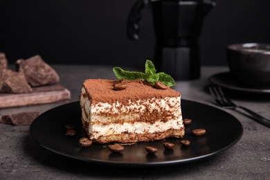 Photo of Composition with tiramisu cake on table against dark background