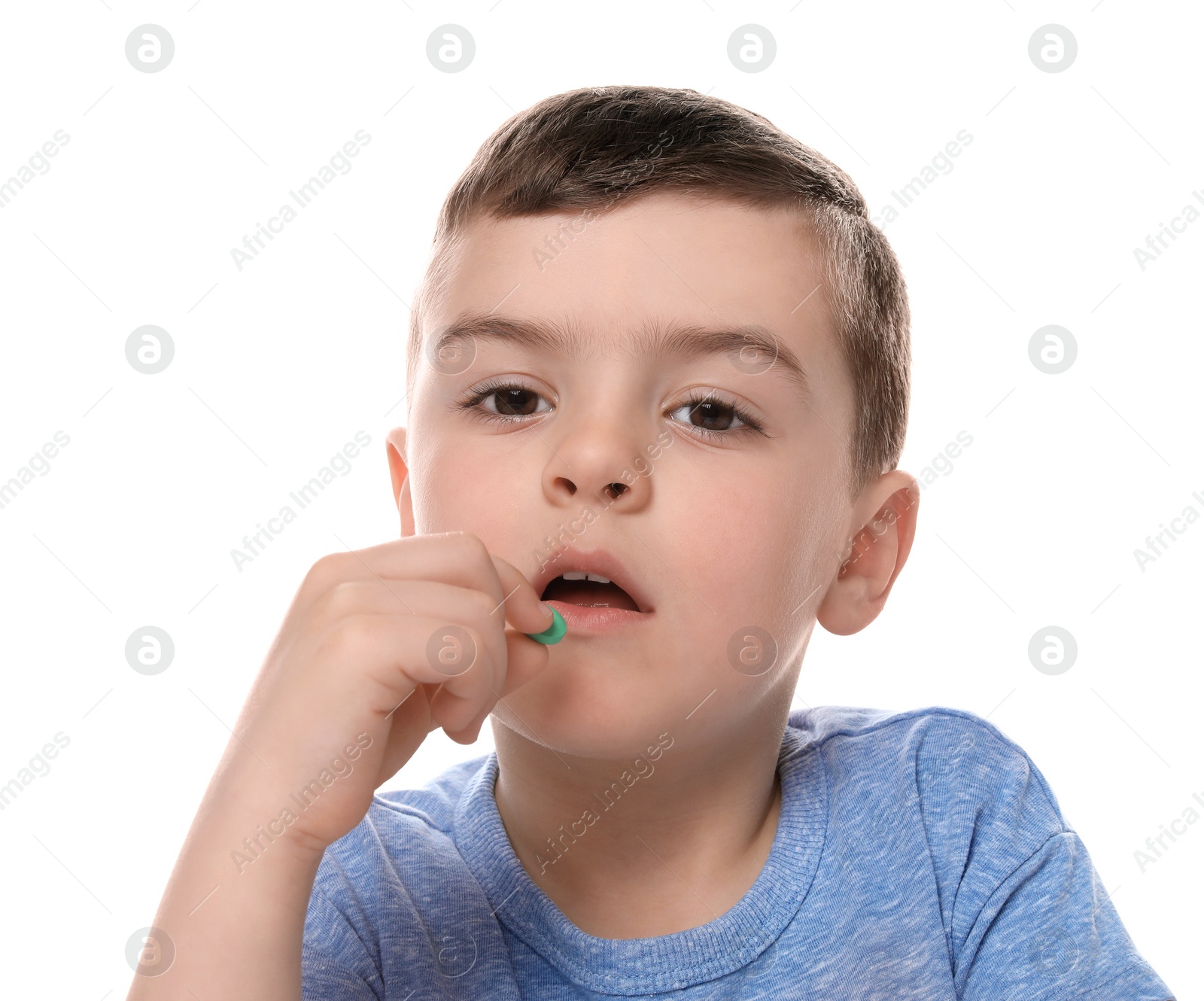 Photo of Little child taking pill on white background. Household danger