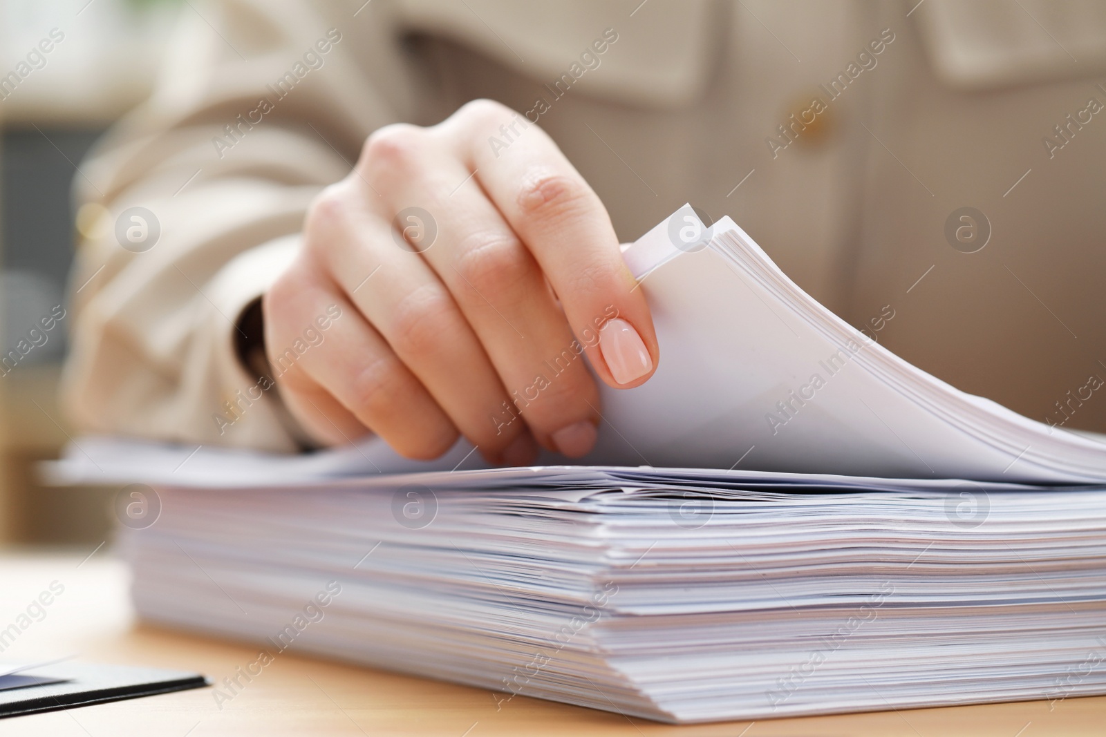 Photo of Woman working with documents at table in office, closeup