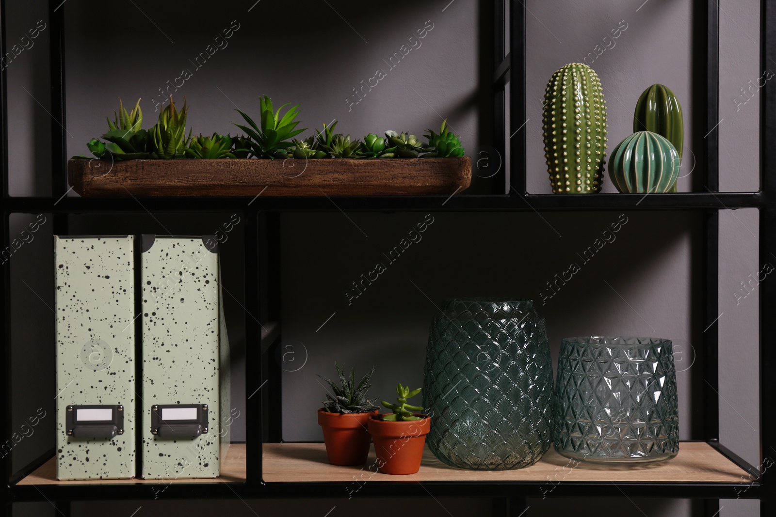 Photo of Shelving with different decor and houseplants near gray wall. Interior design