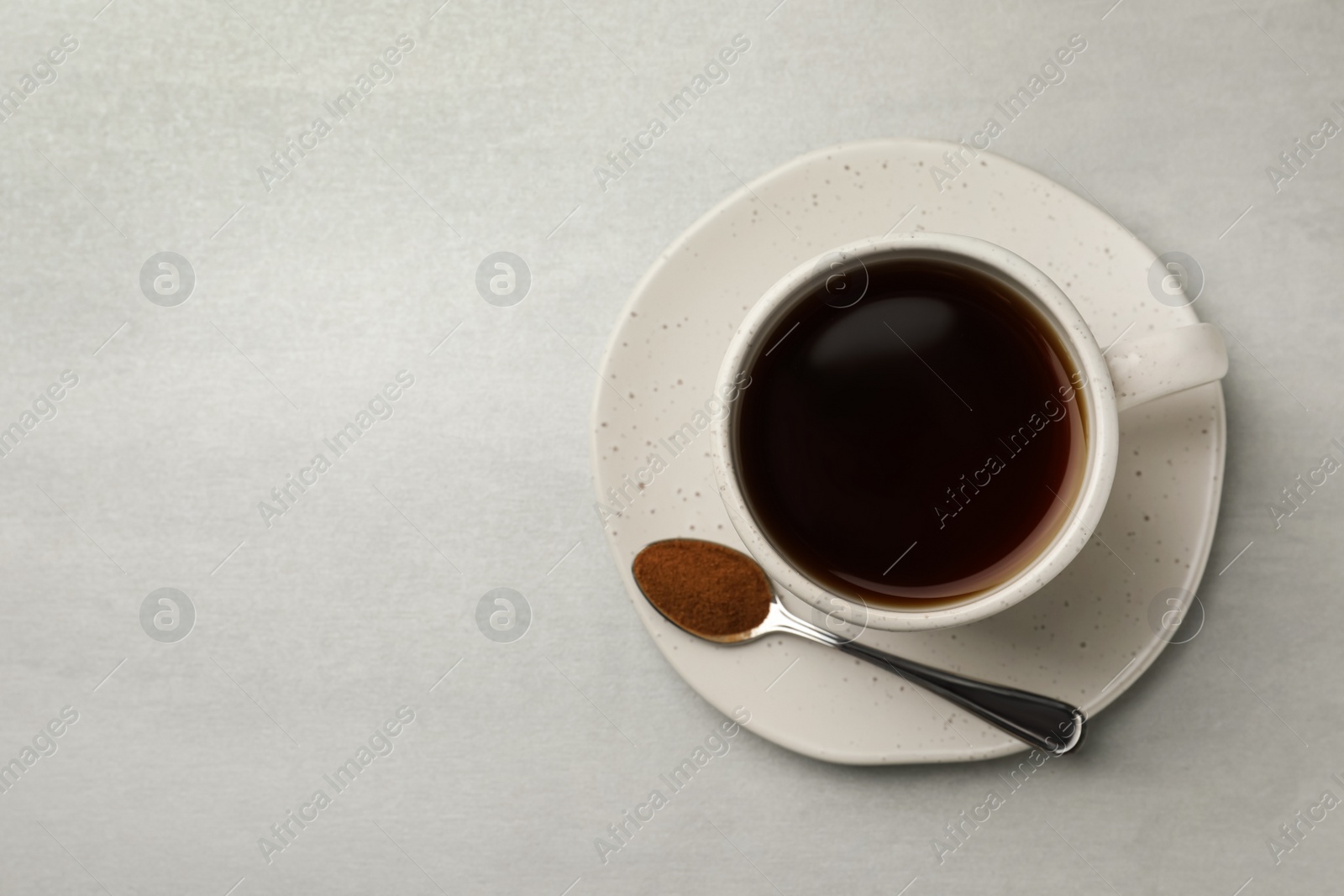 Photo of Cup of delicious chicory drink and spoon with powder on light grey table, top view. Space for text