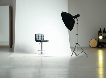 Photo of Photo studio interior with modern chair and professional lighting equipment