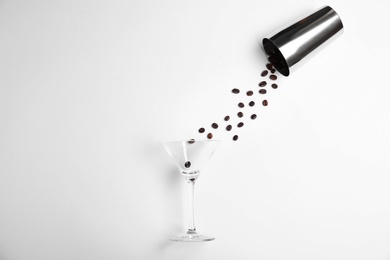 Flat lay composition with glass, coffee beans and shaker on white background. Alcohol cocktail recipe - Espresso Martini