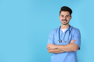 Young medical student in uniform on color background. Space for text