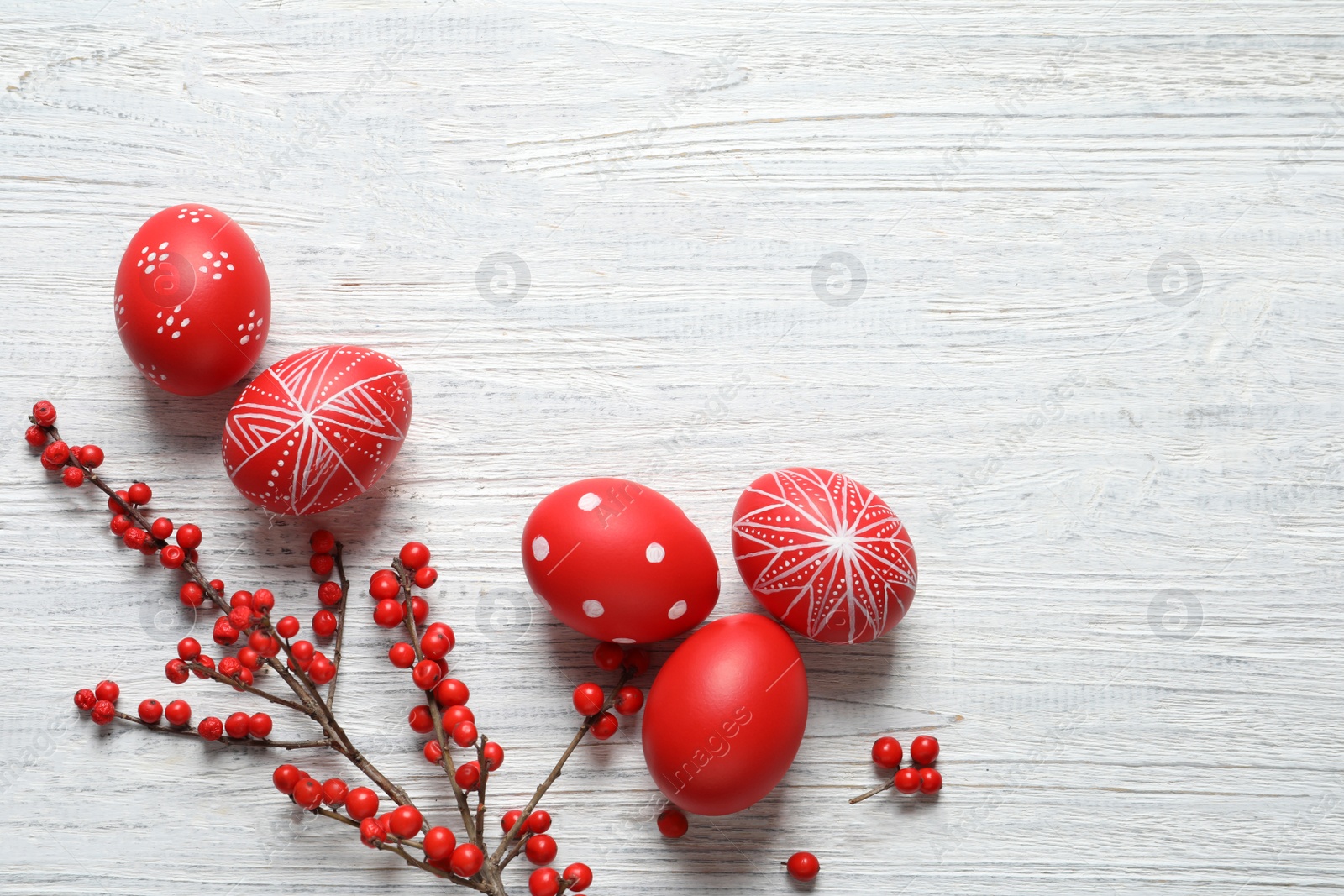 Photo of Flat lay composition with painted Easter eggs on wooden table, space for text