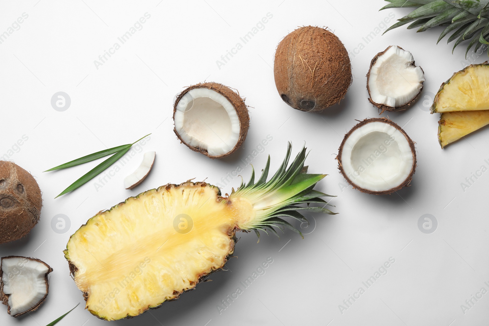 Photo of Composition with coconuts and juicy pineapple on white background, top view